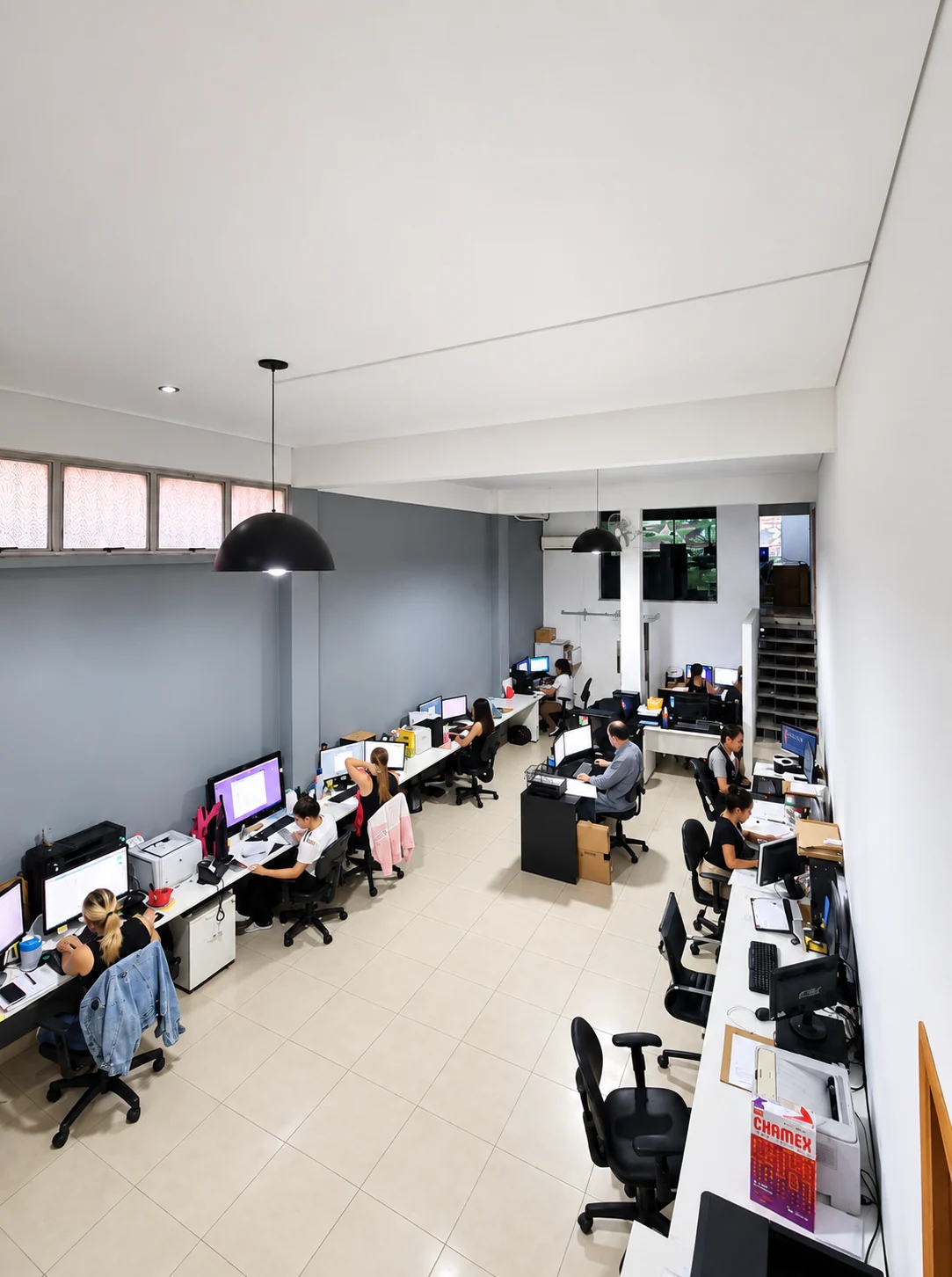 Equipe da Rodriguez Contabilidade trabalhando em bancadas com computadores, na sala de trabalho vista de cima